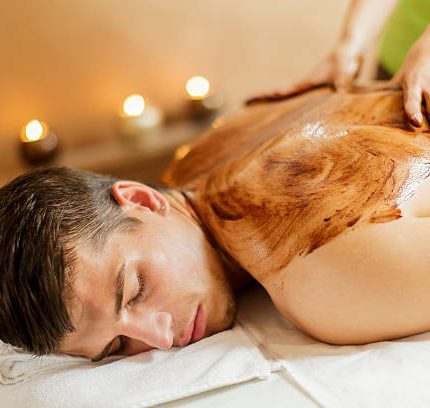 Man die een hot chocolate massage krijgt van een masseuse van Blue Sage bij de opleiding hot chocolate massage