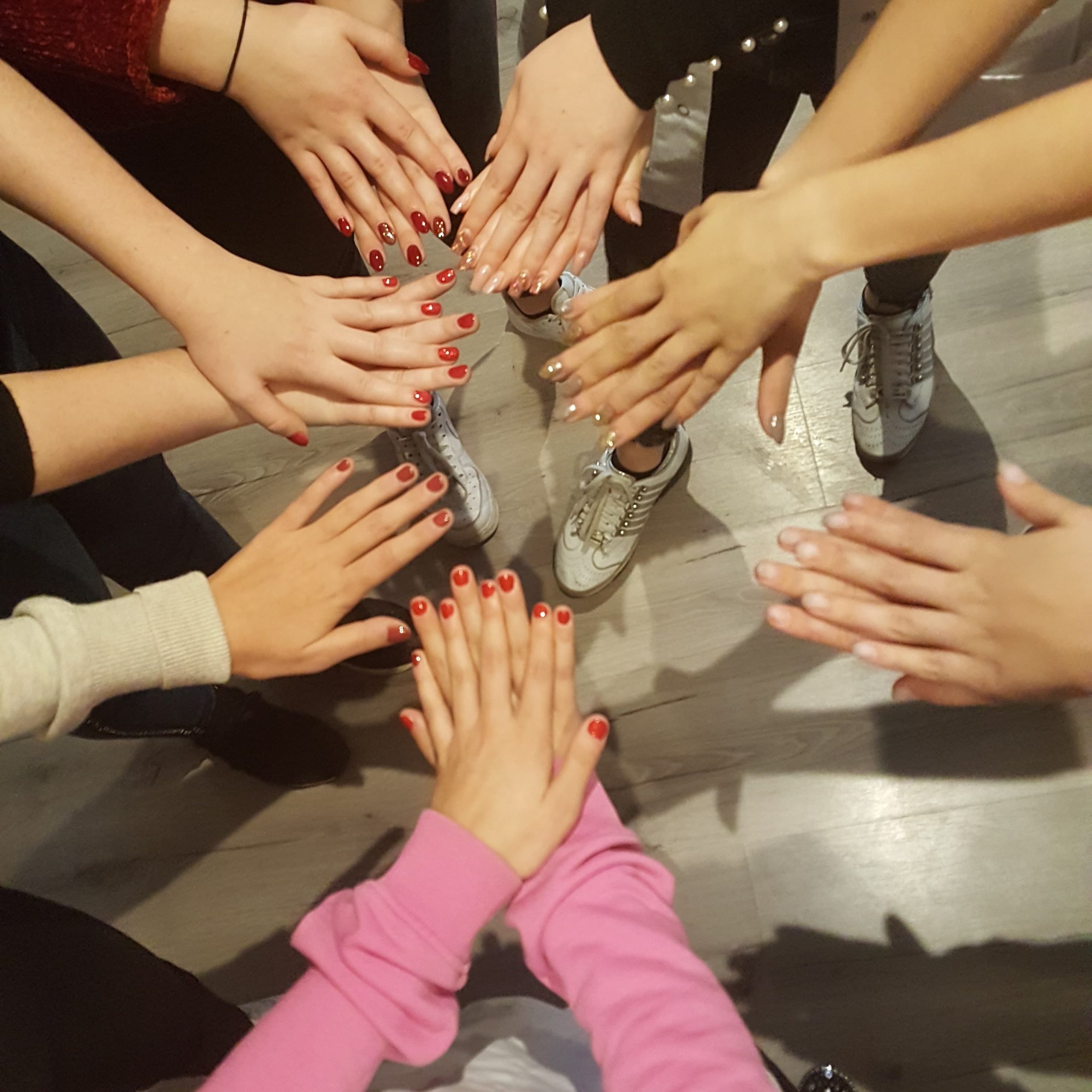 gropes foto van vrouwen die hun armen uitsteken en de handen op elkaar leggen met mooi gelakt gelnagellak op hun nagels van de workshop gel lac