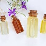 Flessen gezonde natuurlijke massage oliën en helende wilde bloemen bovenaanzicht op witte achtergrond