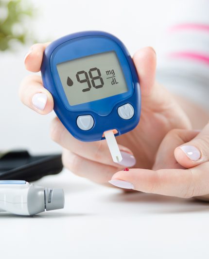 Diabetes die de bloedsuikerspiegel controleert. Vrouw die lancet en glucometer thuis gebruikt.
