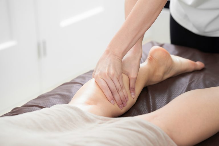 Iemand die een Thaise voet- en been massage uitvoet op iemand zijn been bij de opleiding thaise voet- en beenmassage van Blue Sage