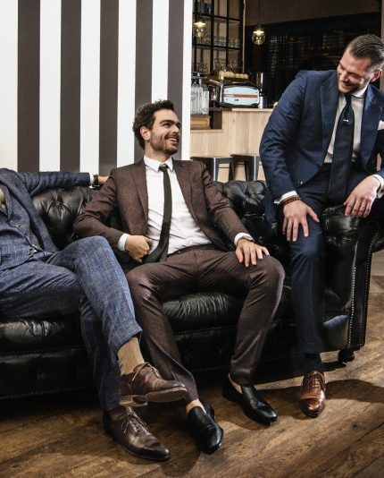 3 men whom sitting in a classy sofa. They are dressed very nice and they all use the high class shave and skincare brand MEN³
